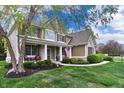Inviting two-story home with a covered front porch, beautiful landscaping, and traditional architectural details at 11233 Rockingham Cir, Fishers, IN 46037
