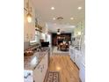 The kitchen showcases white cabinets, hardwood floors and a view into the living room at 1205 N Gibson Ave, Indianapolis, IN 46219