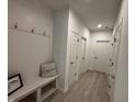 Bright entryway featuring a built-in bench with storage and durable light-colored wood-look flooring at 1221 Malbec Cir, Westfield, IN 46074