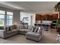 Open-concept living room with a large sectional couch that seamlessly connects to a modern kitchen at 1221 Malbec Cir, Westfield, IN 46074
