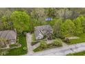 Aerial view of a home with a spacious driveway and lush landscaping, backing up to a natural tree preserve at 13 Ridgeline Dr, Brownsburg, IN 46112