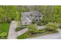 Aerial view of a charming brick house with landscaped gardens and a lush green lawn, surrounded by mature trees at 13 Ridgeline Dr, Brownsburg, IN 46112