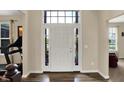 Bright foyer showcases a white front door with sidelights, hardwood floors, and views into adjacent rooms at 13728 Oliver Ln, Carmel, IN 46074