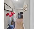 View of the hallway with decor, lighting, hardwood flooring, and access to multiple rooms at 1401 E 24Th St, Muncie, IN 47302