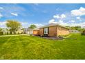 Side view of brick house with manicured lawn featuring dark mulch for landscaping at 1823 E 44Th St, Anderson, IN 46013