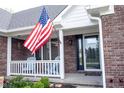 American flag on the front porch with blue Adirondack chairs creates a welcoming entrance to the home at 1893 Water Oak Way, Avon, IN 46123
