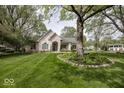 Charming home with manicured lawn, mature trees, and an inviting entrance at 1920 E 81St St, Indianapolis, IN 46240