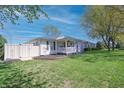 Inviting home with a well-kept lawn, charming white fence, and a vibrant green leafy tree at 2305 Caldwell Pl, Columbus, IN 47201