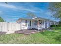 Quaint home featuring a fenced yard, complemented by lush green grass and manicured garden beds at 2305 Caldwell Pl, Columbus, IN 47201