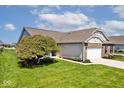 Charming single story home showcasing well-kept lawn, lovely landscaping, and a two-car garage with a wide driveway at 2342 Sheek Rd, Greenwood, IN 46143