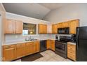 Well-lit kitchen with black appliances, light oak cabinetry, and a neutral countertop at 2523 Gammon Dr, Indianapolis, IN 46234