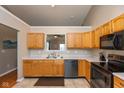 Bright kitchen featuring sleek black appliances, light oak cabinetry, and a view to the breakfast nook at 2523 Gammon Dr, Indianapolis, IN 46234
