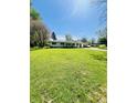 Well-maintained single-story house with lush green lawn, mature trees, and a clear blue sky at 2871 N Talley Rd, Columbus, IN 47203