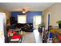 Open-concept living room with ceiling fan, dining area, and tile floors at 321 Harlan St, Indianapolis, IN 46201