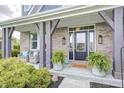 Inviting front porch featuring stylish chairs, a 'hello' doormat, and lush potted ferns at 3387 Keystone Pass, Plainfield, IN 46168