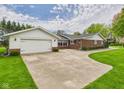 Exterior view showcasing the home's attached garage and expansive driveway at 3824 Oakwood Blvd, Anderson, IN 46011