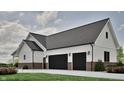 Spacious two-car garage with black doors, white siding, and brick accent, offering ample parking at 3932 Besbie Way, Bargersville, IN 46106