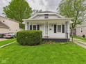 Charming home featuring a well-maintained lawn and a welcoming front porch with decorative iron supports at 411 Mccullen St, Chesterfield, IN 46017