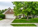 A lovely two-story house with brick and siding, a two-car garage, and a green lawn with a mature tree at 4227 Short Ter, Carmel, IN 46033
