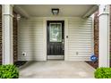 Close-up of the front porch featuring a decorative front door with sidelights and a security system at 4227 Short Ter, Carmel, IN 46033