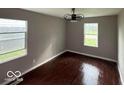 Bedroom featuring hardwood floors, two windows, neutral wall color, and a ceiling fan at 4456 N Kenyon Dr, Indianapolis, IN 46226