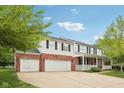 Charming two-story home with brick accents, white siding, covered porch, a three car garage and a wide driveway at 5 Statesman Ct, Brownsburg, IN 46112