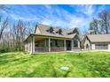 Beautiful home featuring a large porch, detached garage and lush green lawn at 5386 W 1100 N, Fountaintown, IN 46130