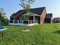 Expansive backyard showcasing a well-maintained lawn, a deck, and a covered porch area for relaxing at 5601 Harness Dr, Greenwood, IN 46143