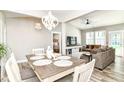Open-concept dining area with modern chandelier, flowing into the living room and bedroom at 6301 Prospect St, Indianapolis, IN 46203