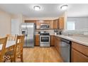 Well-lit kitchen features stainless steel appliances, wood cabinetry, and a dining area with a wooden table at 6333 Pinebark Pl, Indianapolis, IN 46217