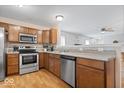 Kitchen with stainless steel appliances, wooden cabinets, and a view of the adjacent living area at 6333 Pinebark Pl, Indianapolis, IN 46217