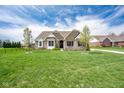 Charming brick home with a well-manicured lawn and beautiful landscaping at 6784 W May Apple Dr, McCordsville, IN 46055