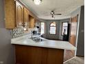 Features wood cabinets, stylish backsplash, a double sink, white countertops, and natural light at 741 Springmill Dr, Mooresville, IN 46158