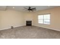 Cozy living room features a fireplace, ceiling fan, neutral carpet, and a window at 7643 Belmac Ln, Camby, IN 46113