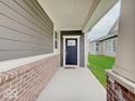 Inviting covered entry features a dark front door, brick accents, and a 'hello' doormat at 8593 Hudson Way, Brownsburg, IN 46112