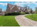 Brick home showing curving driveway and lush landscaping at 9719 Decatur Dr, Indianapolis, IN 46256