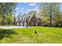 Attached three car garage with a basketball hoop and an expansive driveway at 10220 N Serenity Ln, Mooresville, IN 46158