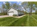 White outbuilding with an overhead door and well-manicured lawn at 10220 N Serenity Ln, Mooresville, IN 46158