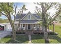 Attractive two-story farmhouse featuring a covered porch with rocking chairs and an attached garage at 10776 S 250 W, Flat Rock, IN 47234