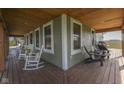 Inviting front porch with rustic wood floors, rocking chairs, and view to an adjacent field at 10776 S 250 W, Flat Rock, IN 47234