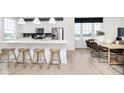 Modern kitchen featuring a large island with seating, stainless steel appliances, and an open dining area at 10959 Belgian Ln, Zionsville, IN 46077