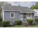 Quaint one-story home with gray siding, trimmed bushes, and 'Welcome' decor at 1643 E Tabor St, Indianapolis, IN 46203