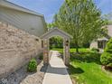 Brick house with a covered walkway and manicured landscaping leading to the main house at 2327 Mimosa Ln, Anderson, IN 46011
