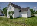 Charming white home with neatly kept yard and wrought iron fence at 2402 N B St, Elwood, IN 46036