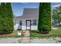 Inviting home with tidy yard and ornamental shrubs and decorative wrought iron fence at 2402 N B St, Elwood, IN 46036