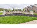 Stone community entrance sign with lush landscaping and decorative topiaries at 2432 Scarlet Oak Dr, Avon, IN 46123