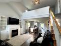 Open-concept living room features a fireplace, vaulted ceilings, and hardwood floors at 3085 Oakmont Dr, Lapel, IN 46051