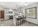 Updated kitchen features white cabinets, stainless steel appliances, and a kitchen island with seating at 4152 S Creekside Dr, New Palestine, IN 46163