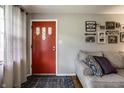 View of the home's entrance featuring a grey wall, a red front door, and grey decor at 5450 Fenmore Rd, Indianapolis, IN 46228