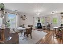 Open-concept dining area with elegant chandelier, hardwood floors, and plenty of natural light at 5550 Sweet River Dr, Indianapolis, IN 46221